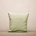 Hufnagel Wool Pillow in Salbeigrün, Frontalansicht auf cremefarbenem Hintergrund